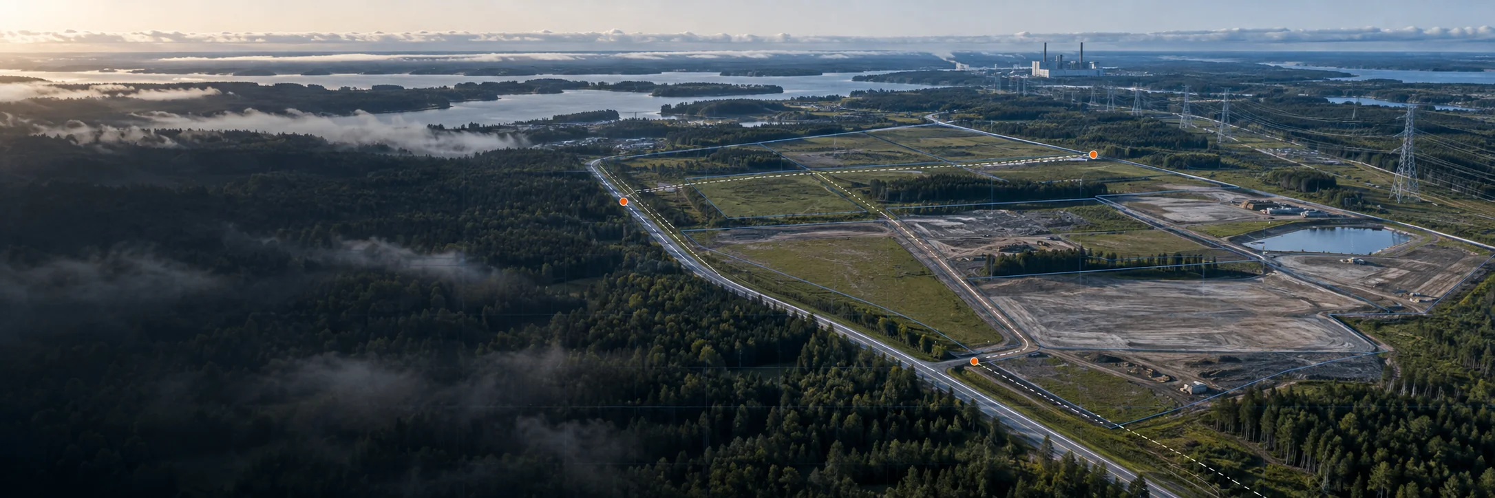 Aerial industrial development site with parcel boundaries, utility corridors, access roads, and orange planning markers